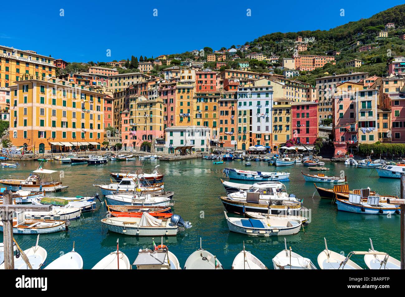 Boote im kleinen Hafen als bunte Häuser im Hintergrund in der italienischen Kleinstadt Camogli. Stockfoto