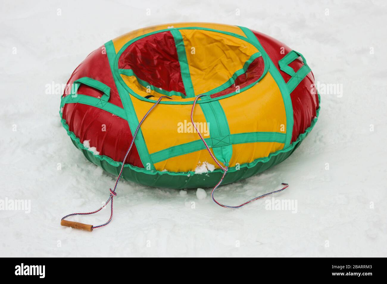 Runde, aufblasbare Kinderschlitten (Schläuche) für Winterfahrten von einem Hügel aus, rot-gelb Stockfoto