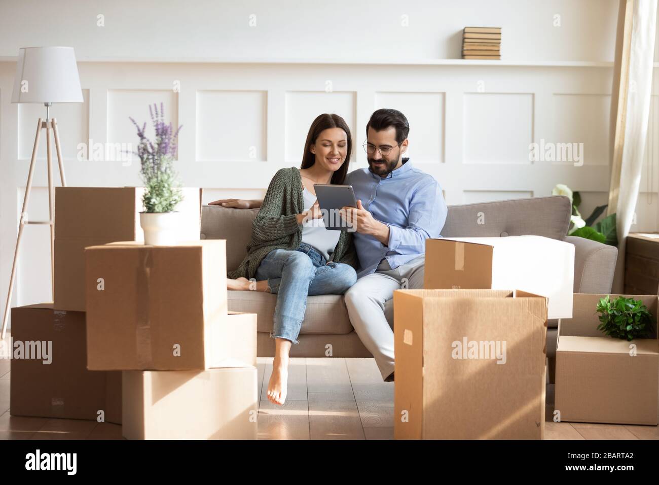 Glückliche Familie kauft Dekorationen online, Moving Day Konzept. Stockfoto