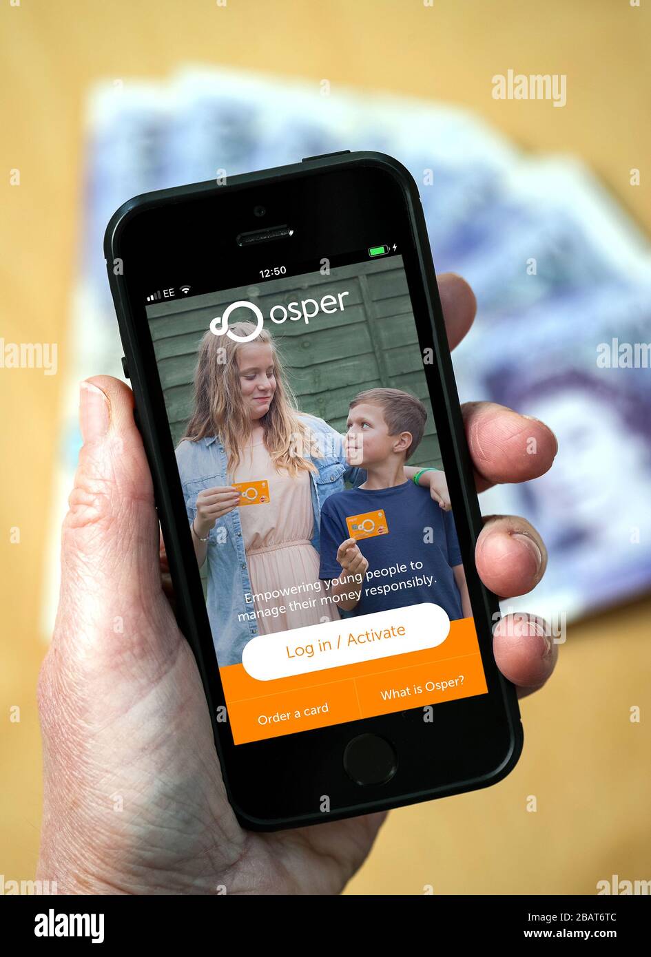 Eine Mutter, die die Osper Pocket Money App auf einem Handy verwendet. (Nur Redaktionelle Verwendung) Stockfoto