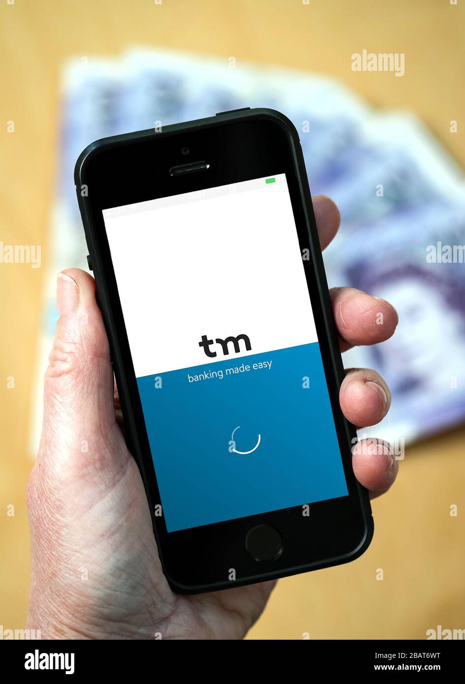 Eine Frau, die die Thinkmoney App auf einem Mobiltelefon verwendet. (Nur Redaktionelle Verwendung) Stockfoto