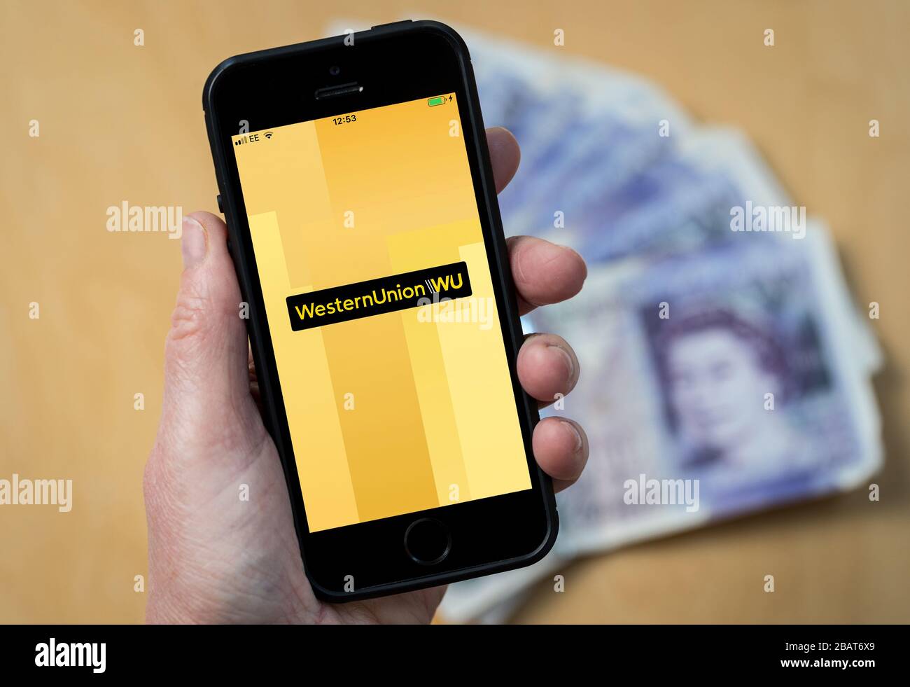 Eine Frau, die die Western Union App auf einem Mobiltelefon verwendet. (Nur Redaktionelle Verwendung) Stockfoto