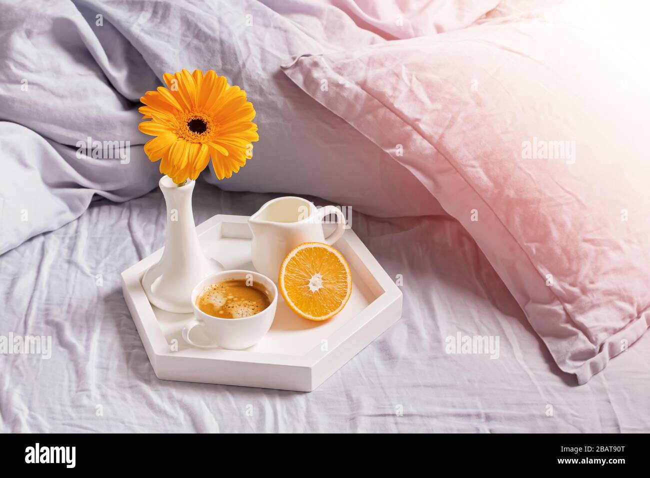 Tablett mit Kaffee, verzierten Blumen und Blumen auf dem Bett Stockfoto