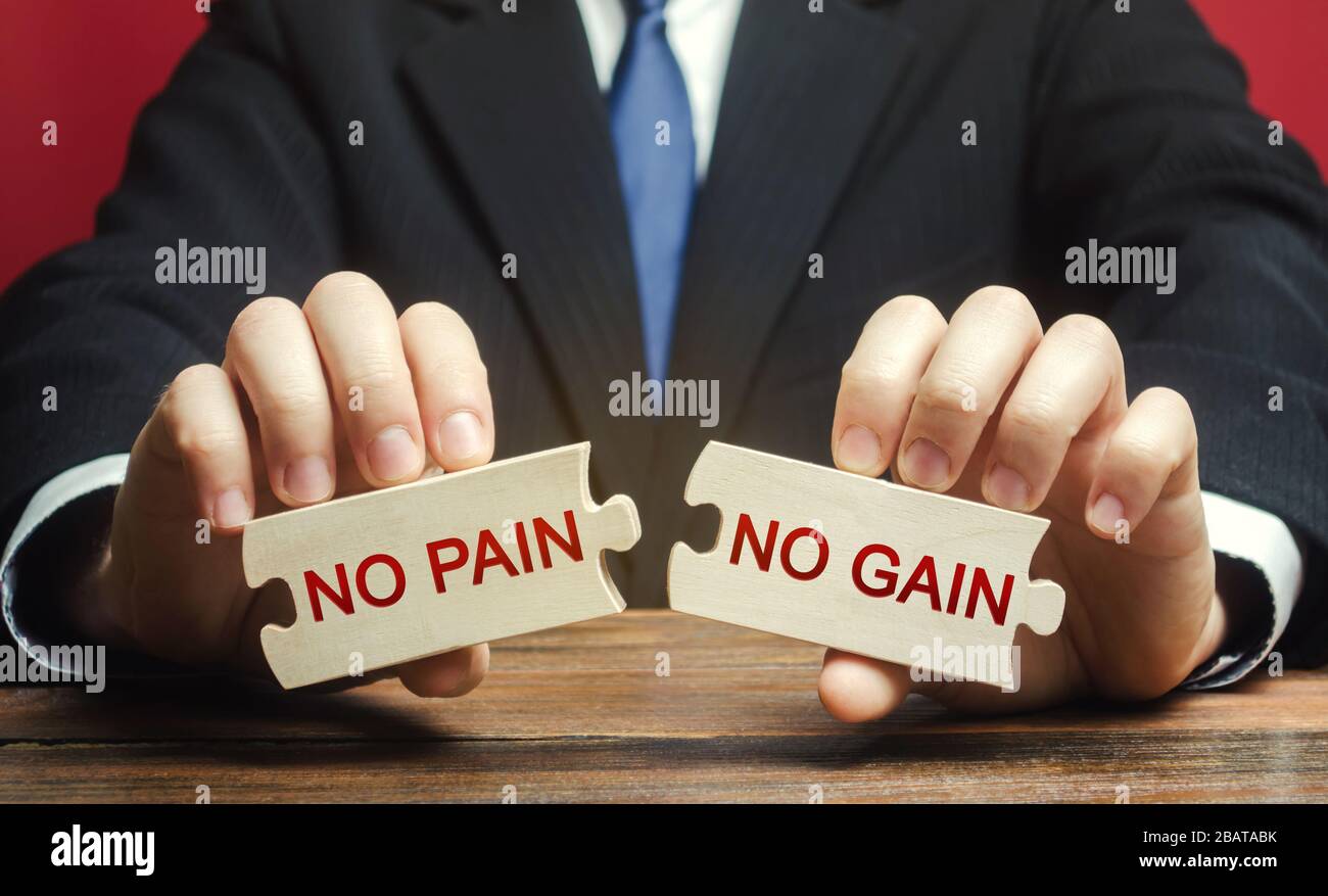 Holzrätsel mit den Worten kein Schmerz, kein Gewinn in den Händen eines Mannes. Motivation, Streben, Zielerreichungskonzept. Management und Veränderung Stockfoto