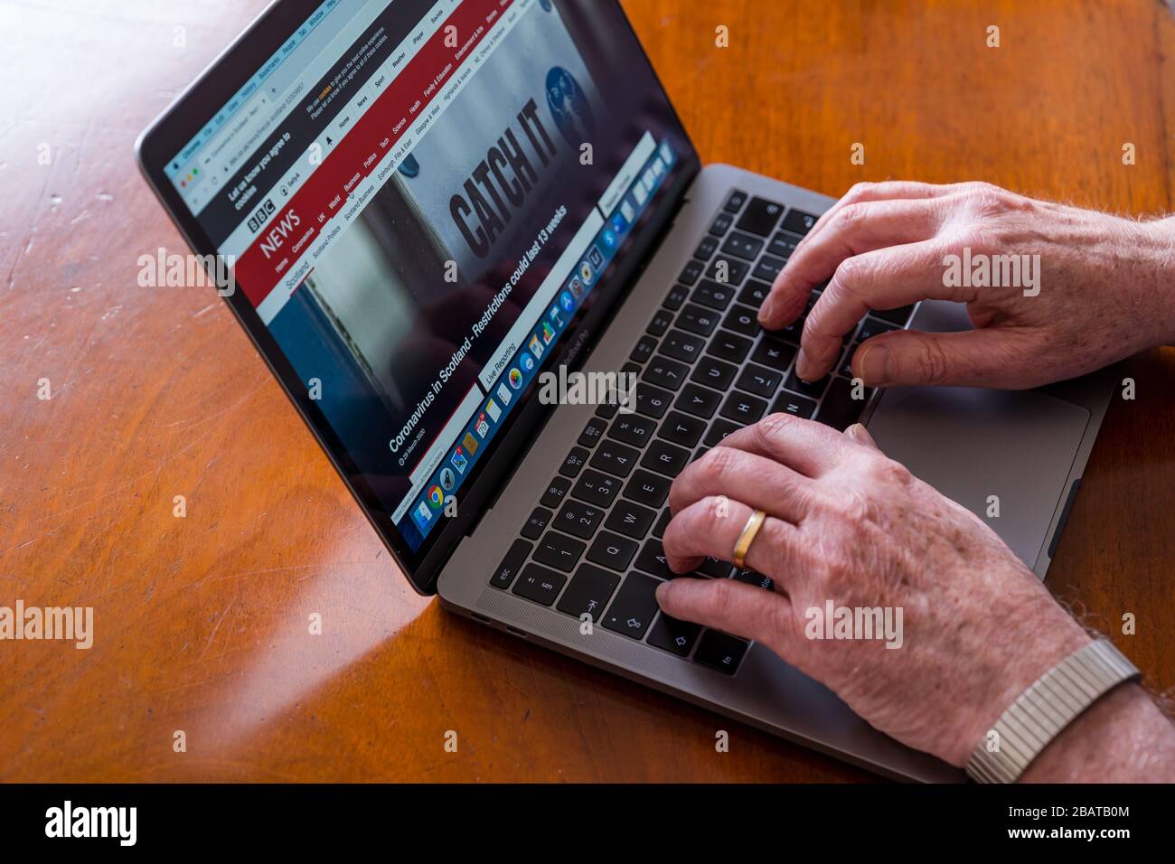 Ein älterer Mann nimmt einen Laptop mit der BBC Scotland News-Website auf dem Bildschirm und Coronavirus News, Großbritannien Stockfoto
