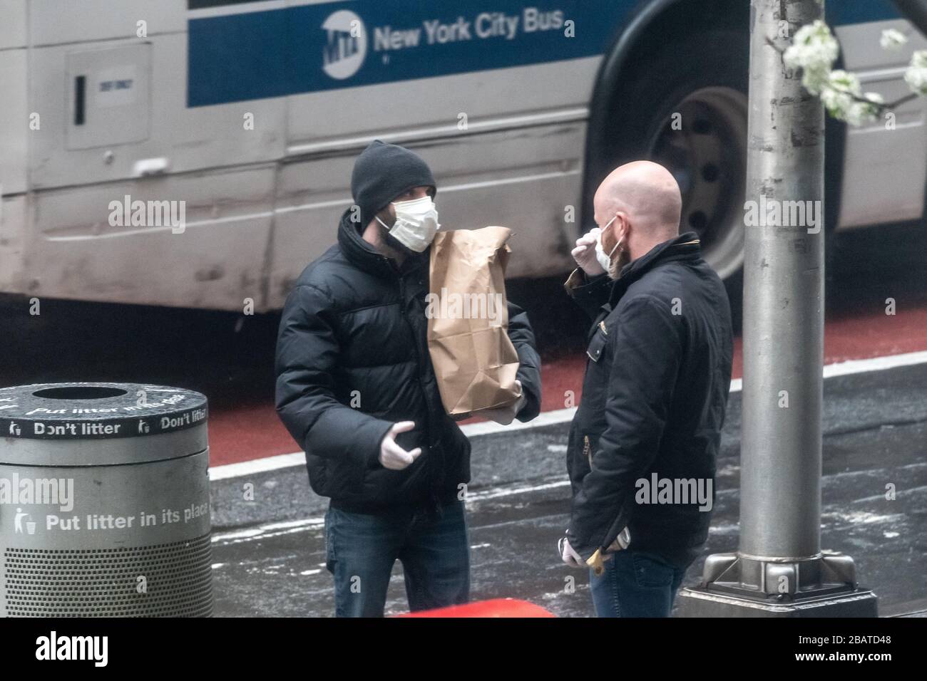 New York, USA. März 2020. Die Menschen tragen Gesichtsmasken, während sie während der Coronavirus-Krise in New York gehen, um Lebensmittel zu kaufen. Kredit: Enrique Shore/Alamy Live News Stockfoto