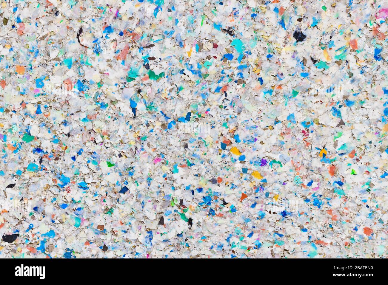 Mehrfarbiger Recycling-Kunststoff-Hintergrund - Nachhaltigkeitskonzept: Raue Struktur einer zersetzenden, verwitterten Recycling-Kunststoffplatte Stockfoto