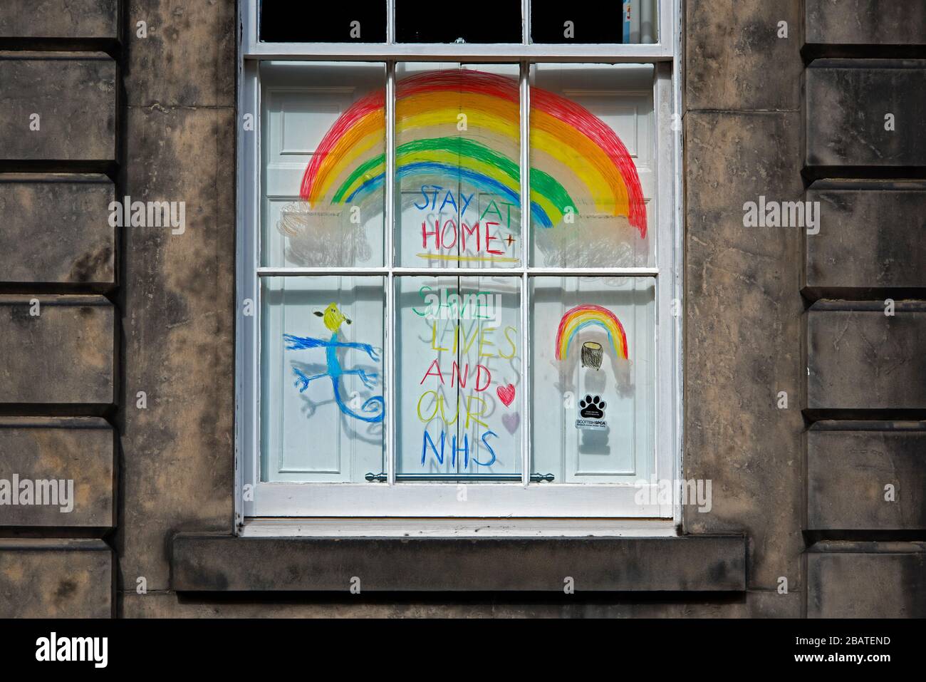 Regenbogen in einem Fenster, um die Passanten während des covid-19-Ausbruchs aufzuheitern. Neustadt, Edinburgh, Schottland, Großbritannien. Stockfoto