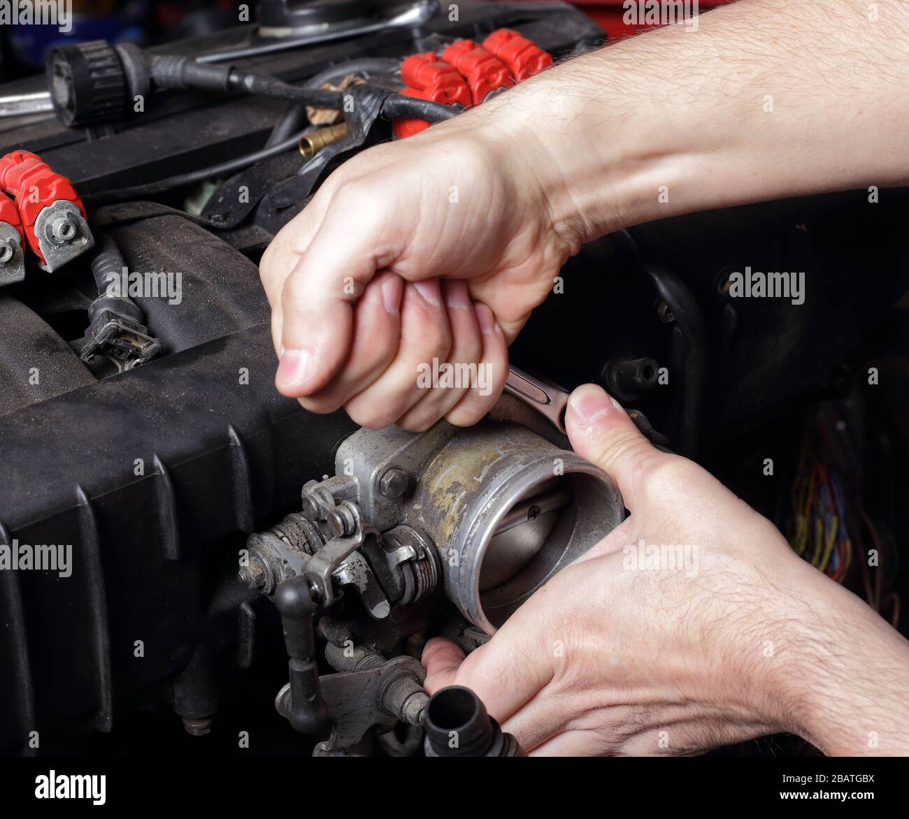 Auto Service - Reparatur des Motors, Mechaniker Hände mit Schraubenschlüssel schraubt die Mutter des Kraftstoffsystems Stockfoto