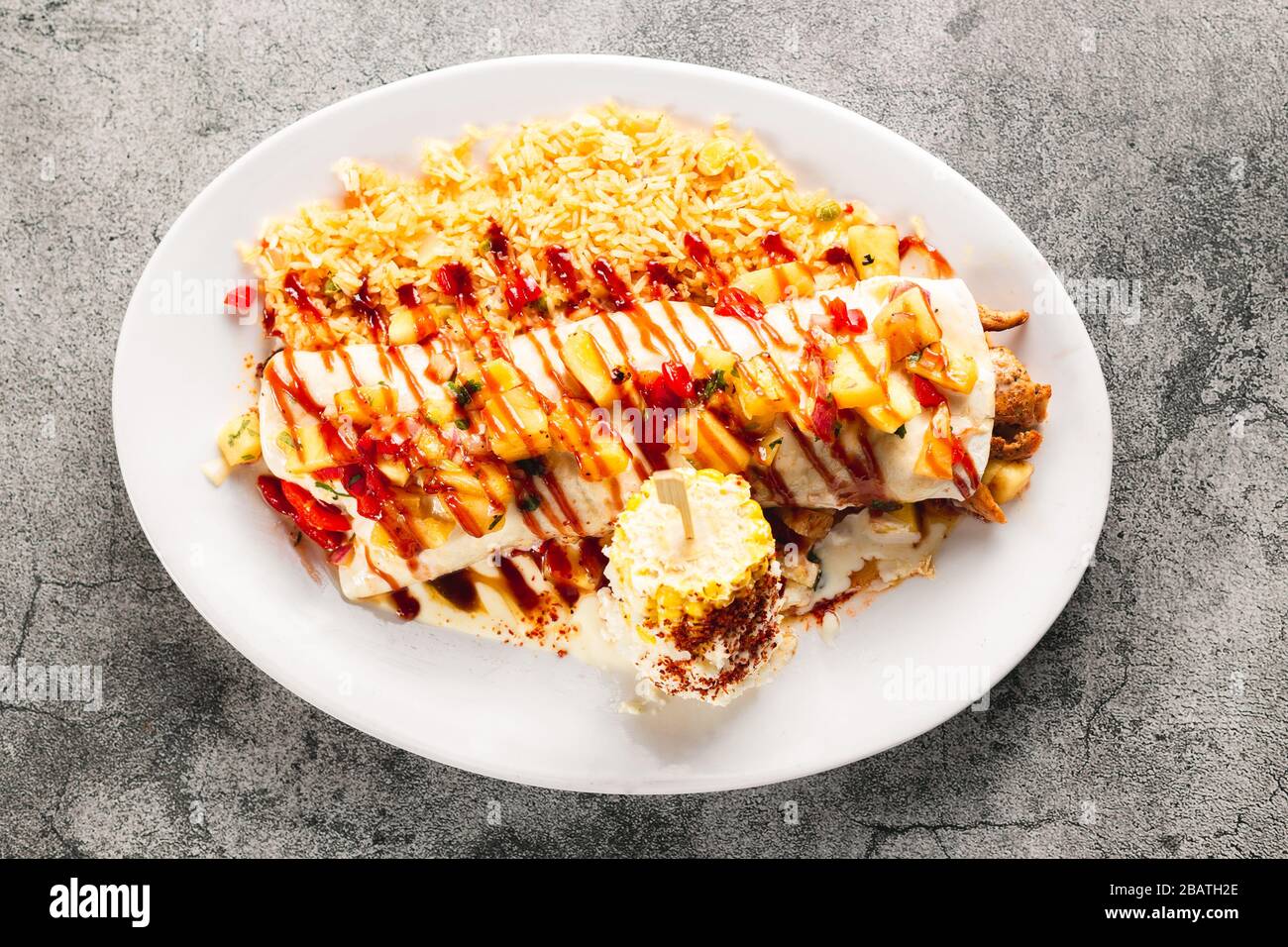 Wunderschönes Hähnchen und Ananasburrito mit Reis und würzigem Mais auf dem Cob Stockfoto