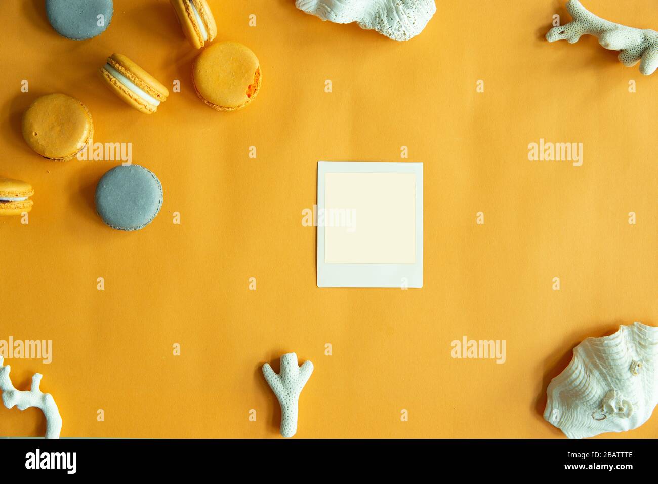 Draufsicht über schmackhafte orangegelbe Makronen und leeres Bild. Konzepte Ideen Hintergrund auf gelbem Papier, Planlay und Kopierraum. Verwendung für Mock up templ Stockfoto