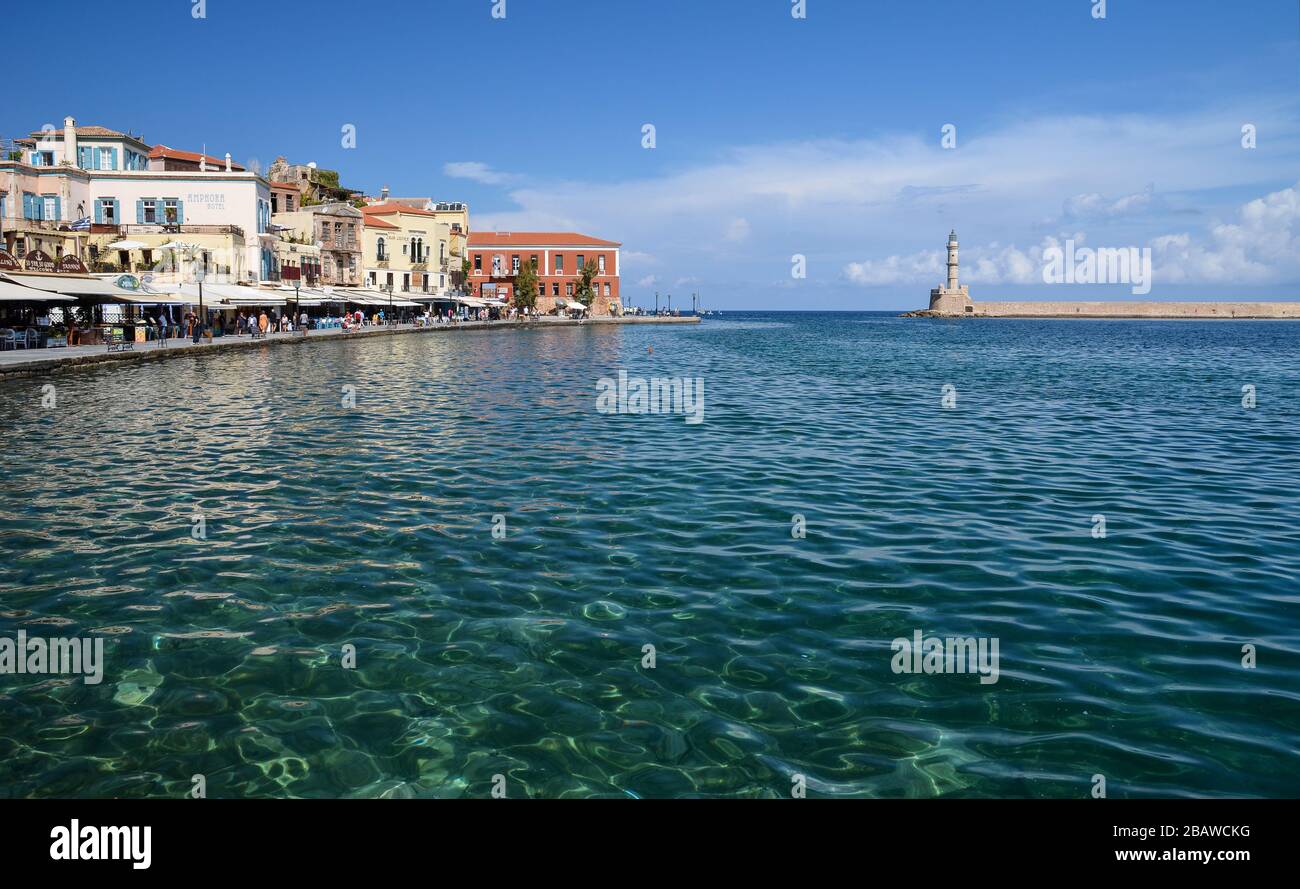 Blick auf den Hafen von Chania und den Leuchtturm, umgeben von klarem Wasser, zweitgrößte Stadt der Insel Crete, Griechenland. Stockfoto