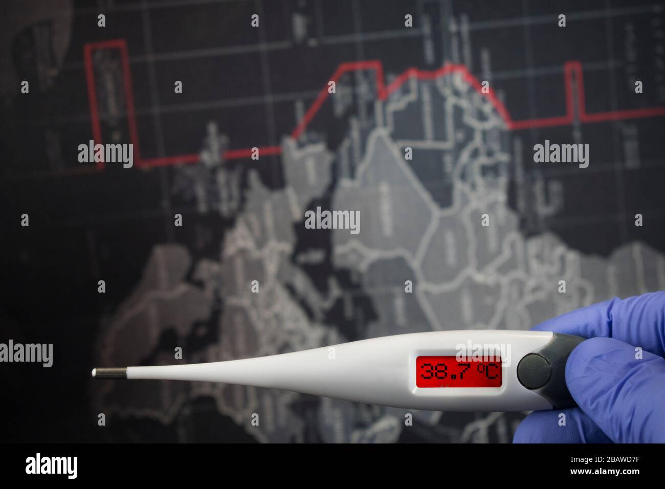 Anzeige von 38,7 C Celsius vor dunklem Hintergrund der Weltkarte. Pfadauswahl inbegriffen.Arzthand mit blauen medizinischen Handschuhen hält digitales Thermometer Stockfoto