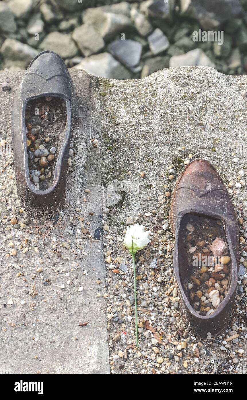 Budapest, Ungarn - 6. November 2019: Schuhe an der Donau-Bank. Denkmal zur Ehrung der Juden, die im zweiten Weltkrieg von Faschisten getötet wurden Eisenschuhe mit Blume von oben fotografiert. Stockfoto