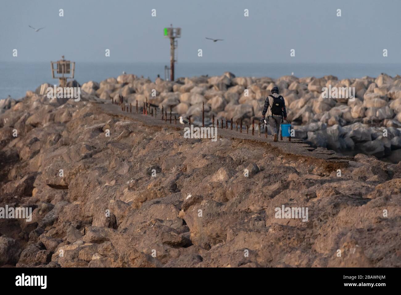 Die Morgendämmerung von Ventura über dem Meer bietet diesem Fischer einen weiteren Tag, um dem zerklüfteten Weg den idealen Angelpunkt zu folgen. Stockfoto