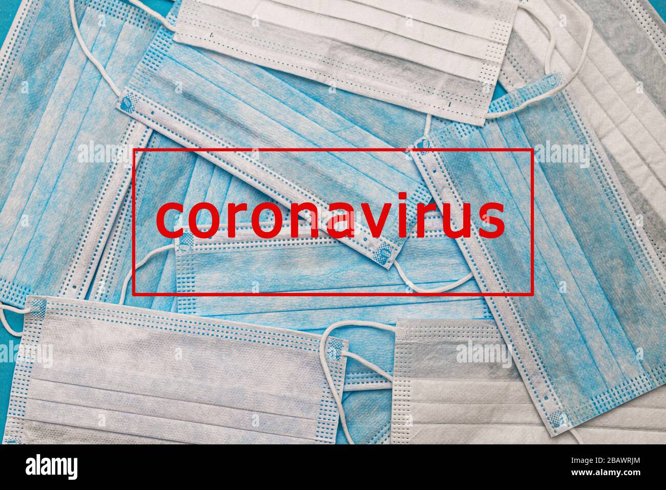 Medizinische Einweg-Gesichtsmasken auf blauem Grund mit der Aufschrift STOP coronavirus Kovid 19. Weltpandemic Coronavirus. Stoppen Sie die Pandemie Stockfoto