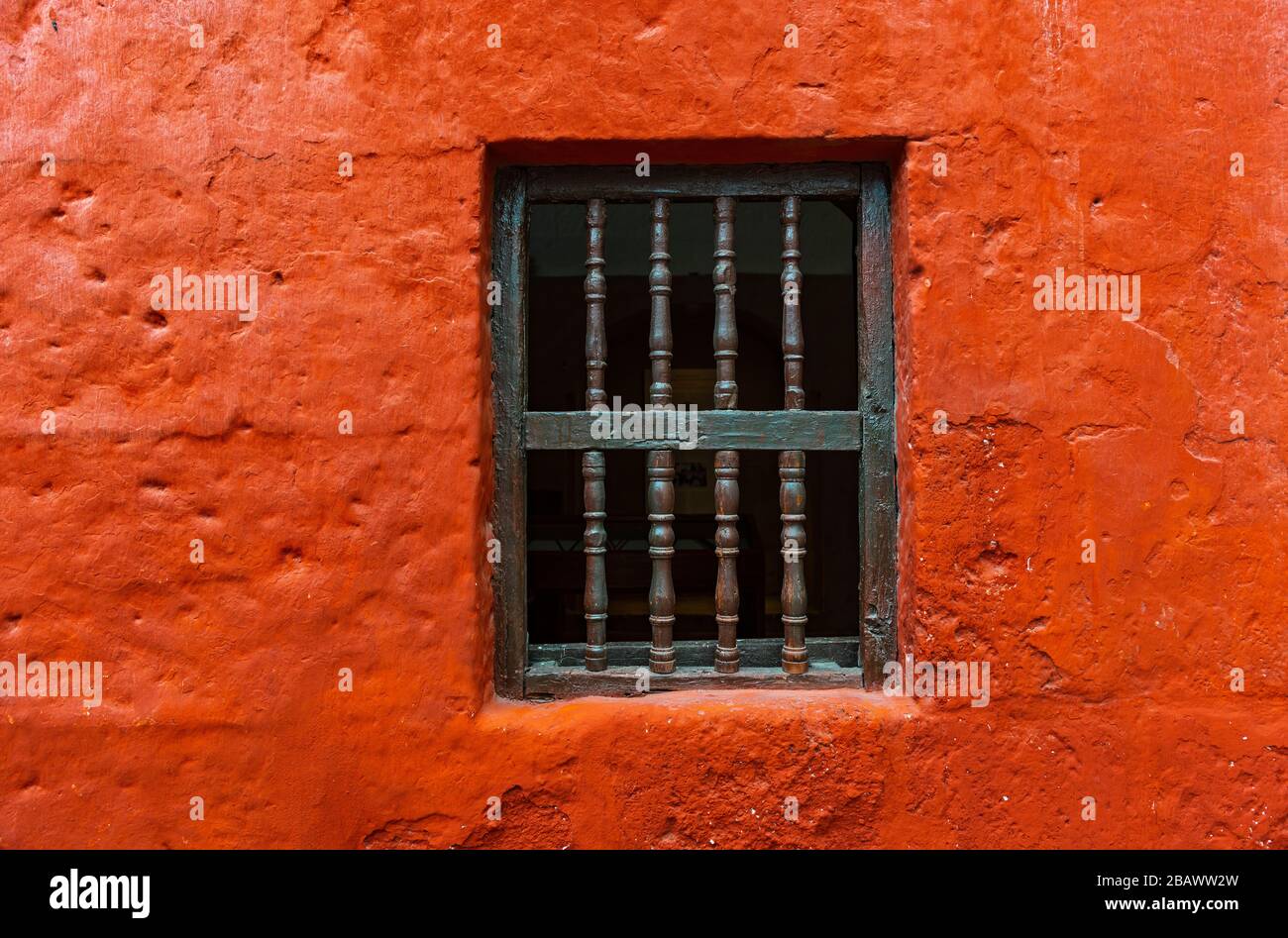 Fenster gegen eine orangefarbene Putzfassade im Kloster Santa Catalina von Arequipa, Peru. Stockfoto