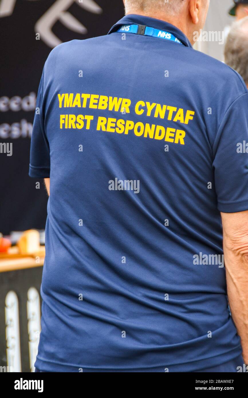 BUILTH WELLS, WALES - JULI 2018: Der Ersthelfer, der in medizinischen Notfällen ausgebildet wurde, trägt ein Hemd mit zweisprachigem Logo. Stockfoto