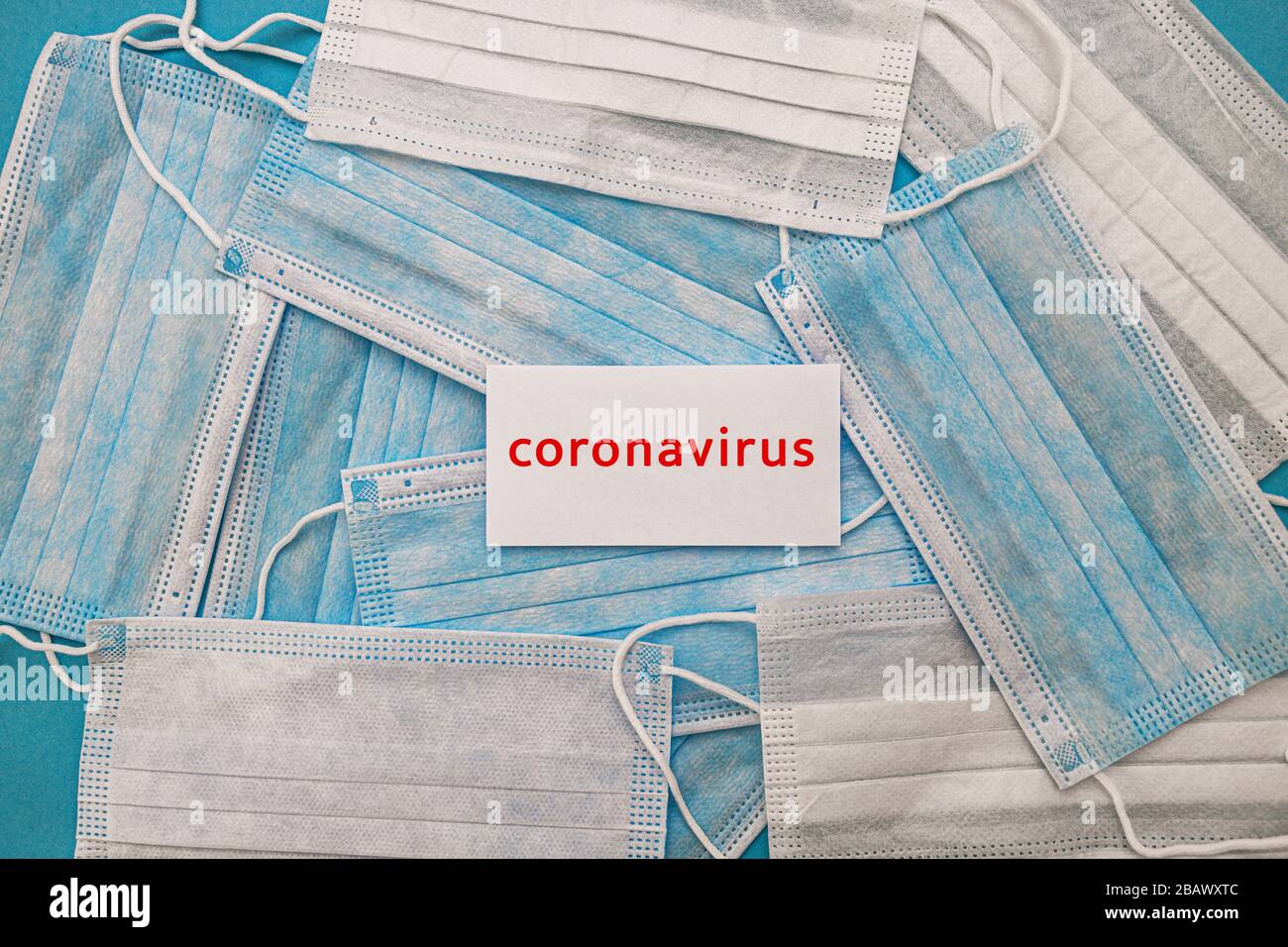 Medizinische Einweg-Gesichtsmasken auf blauem Grund mit der Aufschrift STOP coronavirus Kovid 19. Weltpandemic Coronavirus. Stoppen Sie die Pandemie Stockfoto