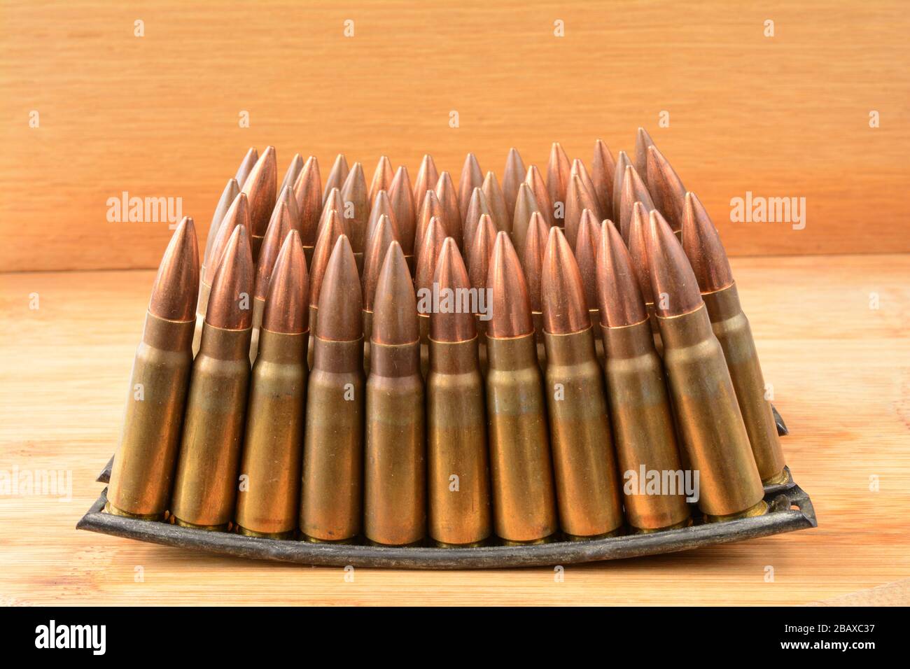 Mehrere gestapelte Clips mit Munition im Kaliber 7,62 x 39 auf Holzhintergrund Stockfoto