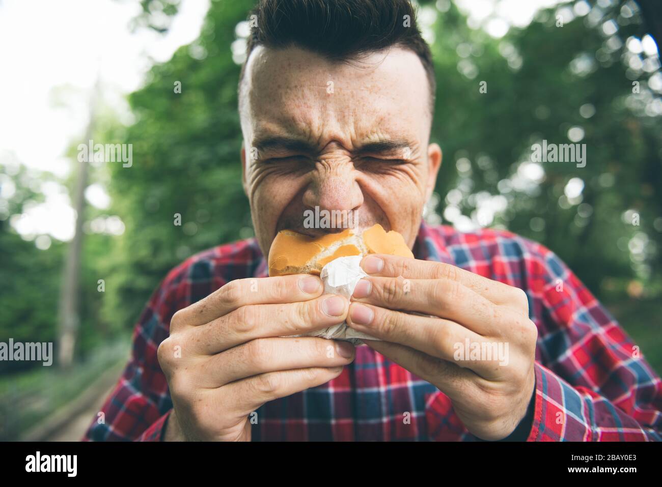 Der Mann isst im Park und genießt köstliches Essen Stockfoto