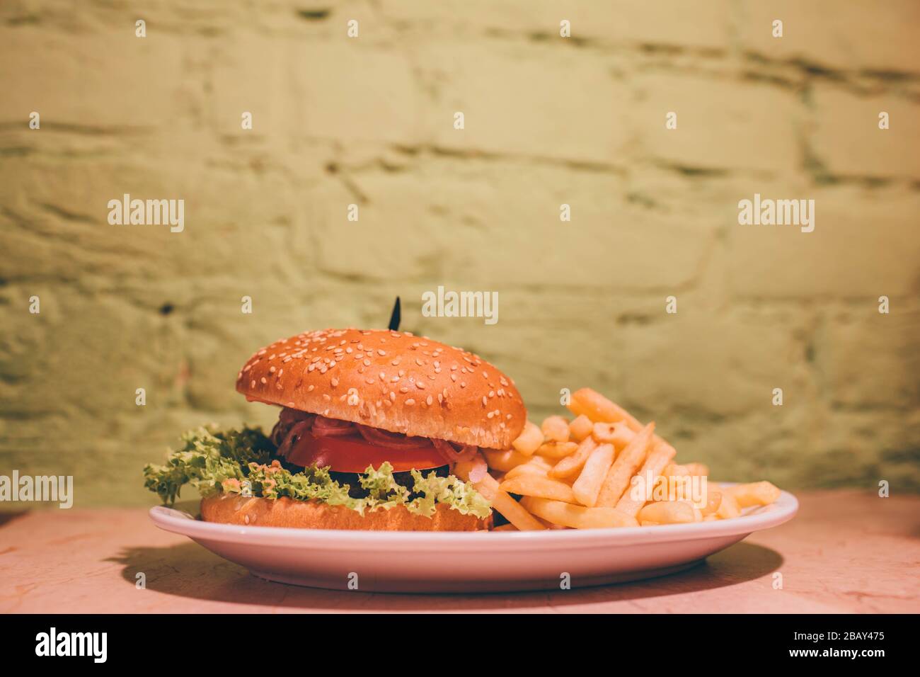 Lecker lecker fetter Burger mit Salat, Tomate und Treffen im Inneren. Auf Platte mit pommes frites liegen. Bild von Fächermahlzeit aus fast Food Stockfoto
