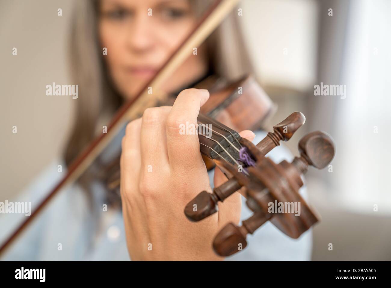 Nahbild einer Frau, die Geige spielt. Geringe Schärfentiefe, Fokus auf Finger Stockfoto