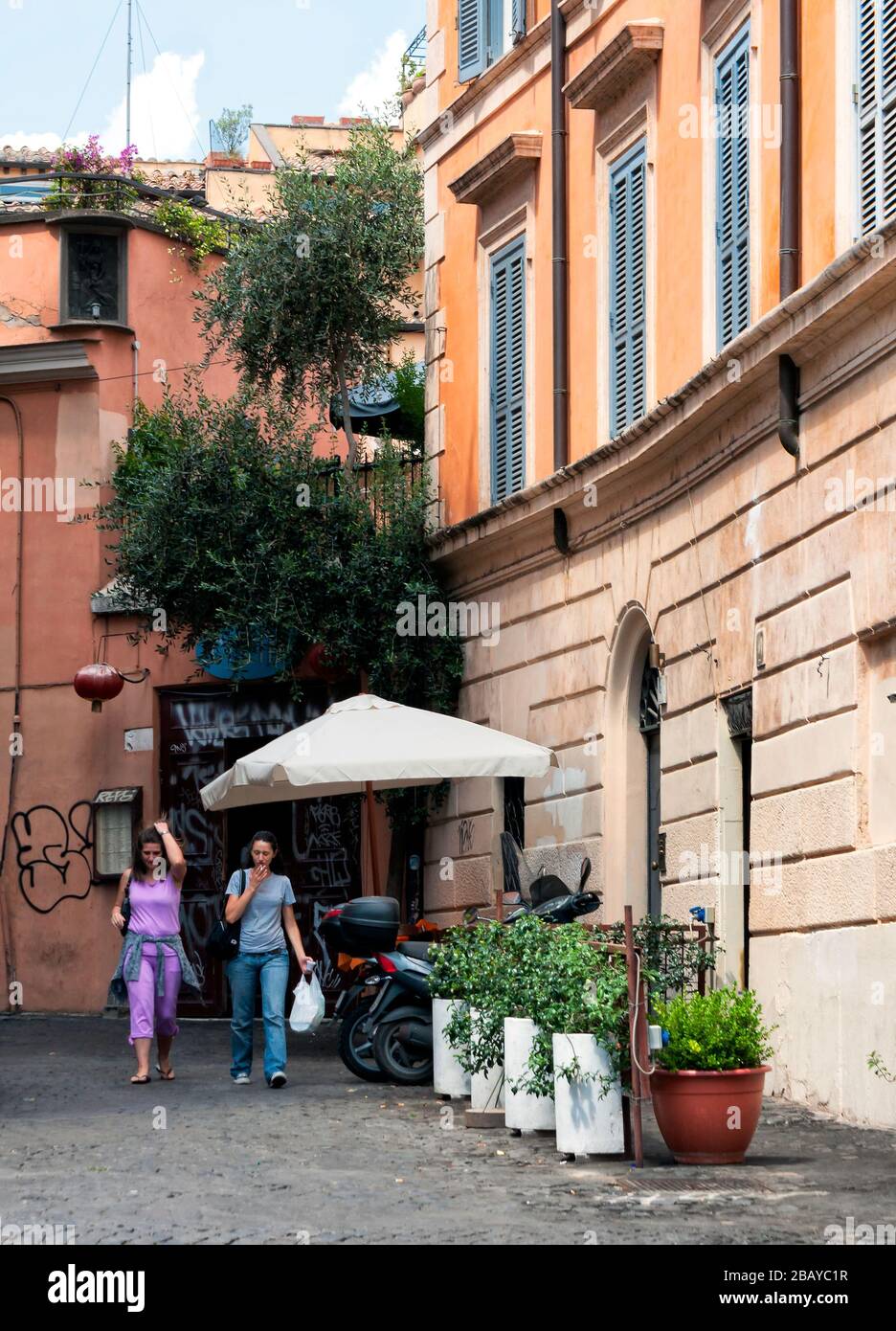 Zwei Frauen, die eine Seitenstraße in Trastevere, Rom, Latium, Italien, Europa, Farbe untergehen Stockfoto