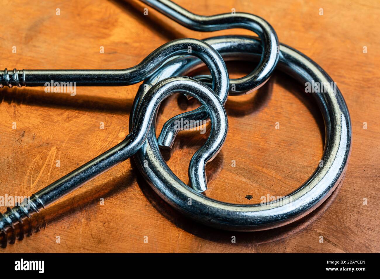 Schraubhaken aus Edelstahl und ein Ring auf einer oxidierten und abgenutzten Kupferoberfläche. Platz für das Schreiben von Kopien an verschiedenen Stellen auf diesem Industriemakro i. Stockfoto