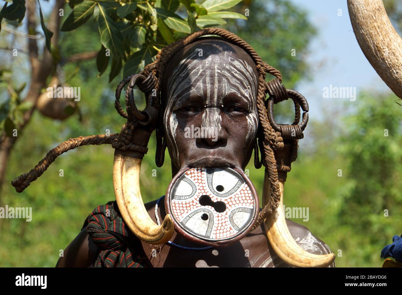 Porträt der Frau Mursi Tribe mit Lippenplatte und Kuh Horn Dekoration Stockfoto