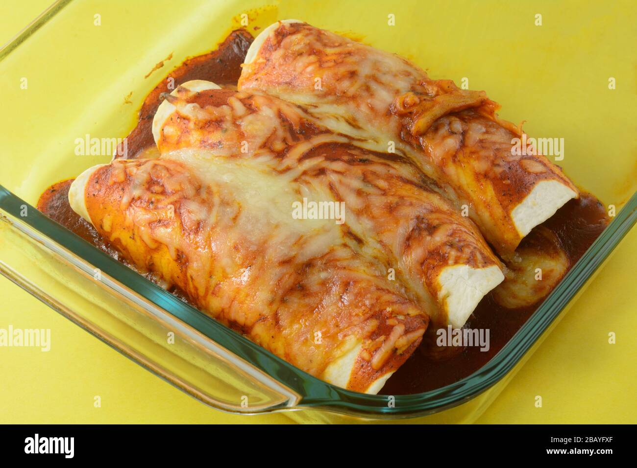 Rinderenchiladarresten mit geschmolzenem Käse in Glasbackpfanne Stockfoto