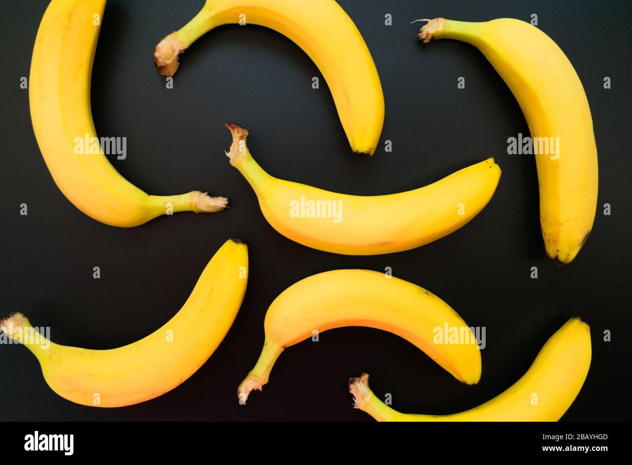 Hintergrund gelber Bananen auf schwarzem Grund. Stockfoto