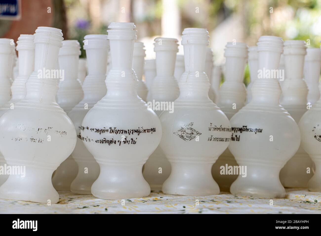 NAKHON PATHOM, THAILAND, MAR 14 2020, EINE Zeile weißer kleiner Flaschen zum Gießen von Wasser in die Schüssel für gutes Karma, buddhistischer Tempel, Wat Samphran, Thailan Stockfoto