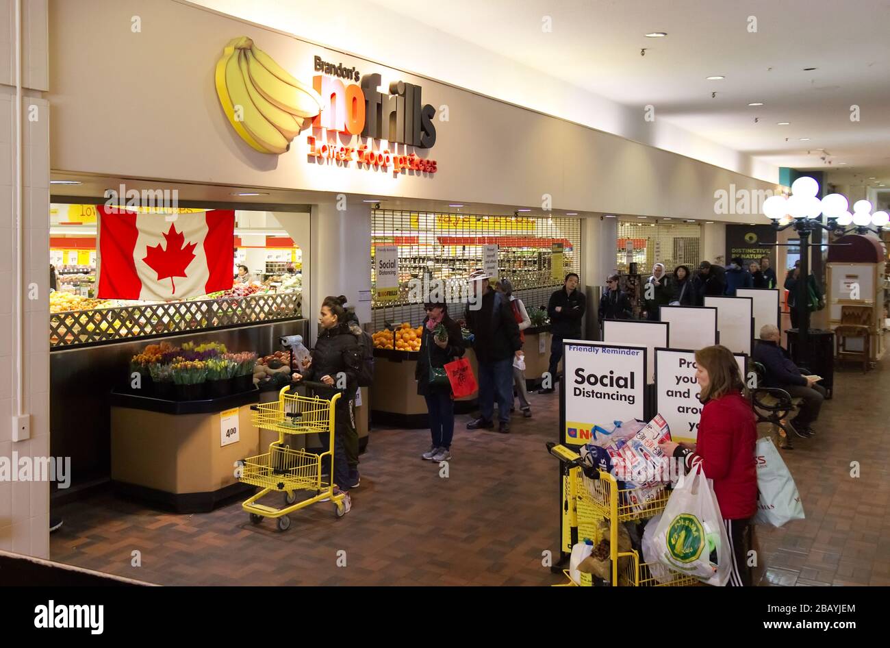 Vancouver, Kanada - 20.2020. März: Die Leute sind bereit, in den No Frills Store zu gehen, der aufgrund von COVID-19 soziale Distanzierungen zwischen den anderen praktiziert. Stockfoto