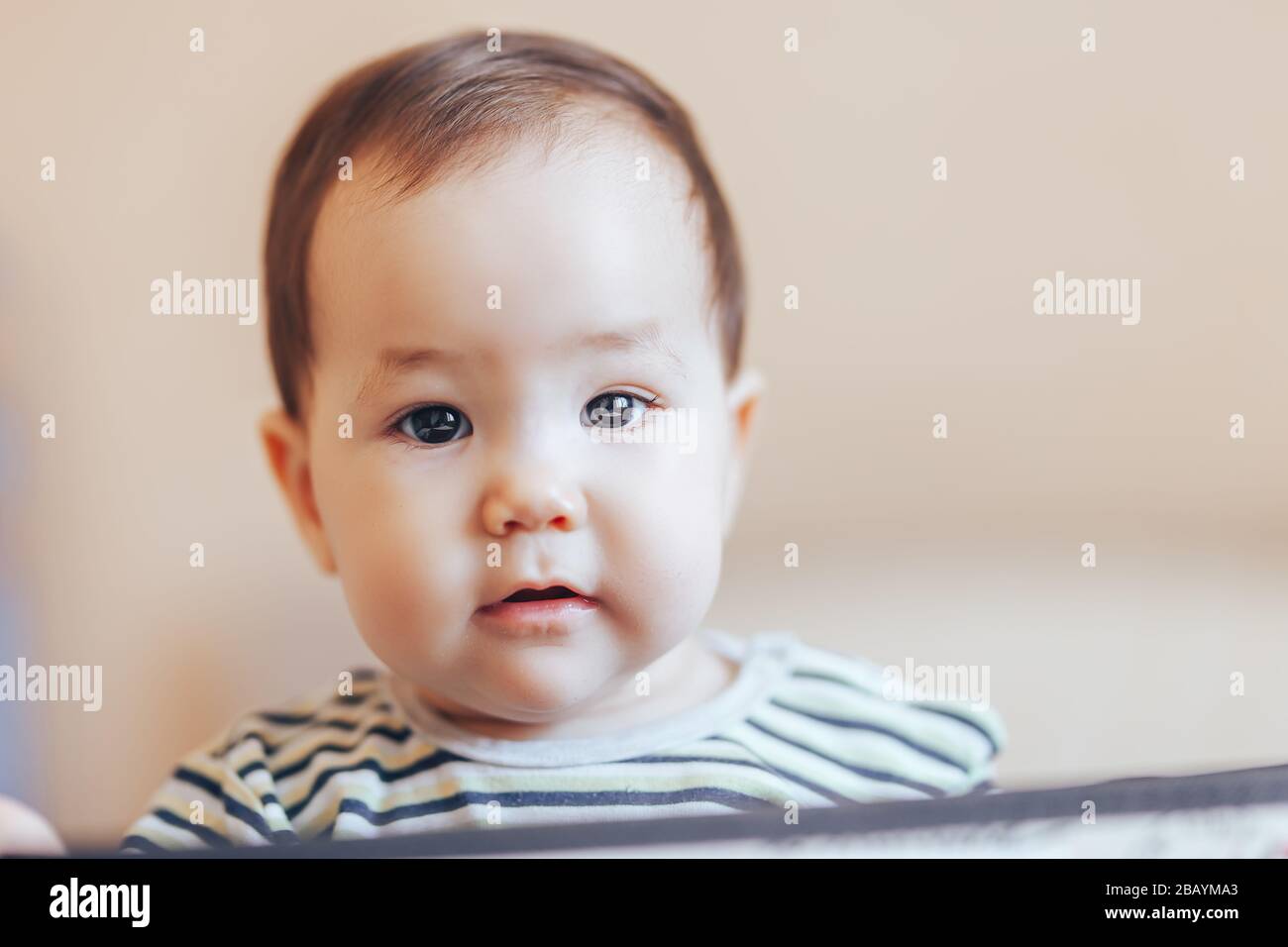 Hübsches Baby Kleinkind Junge oder Mädchen, das in einer Kiste in der Wohnung sitzt Stockfoto