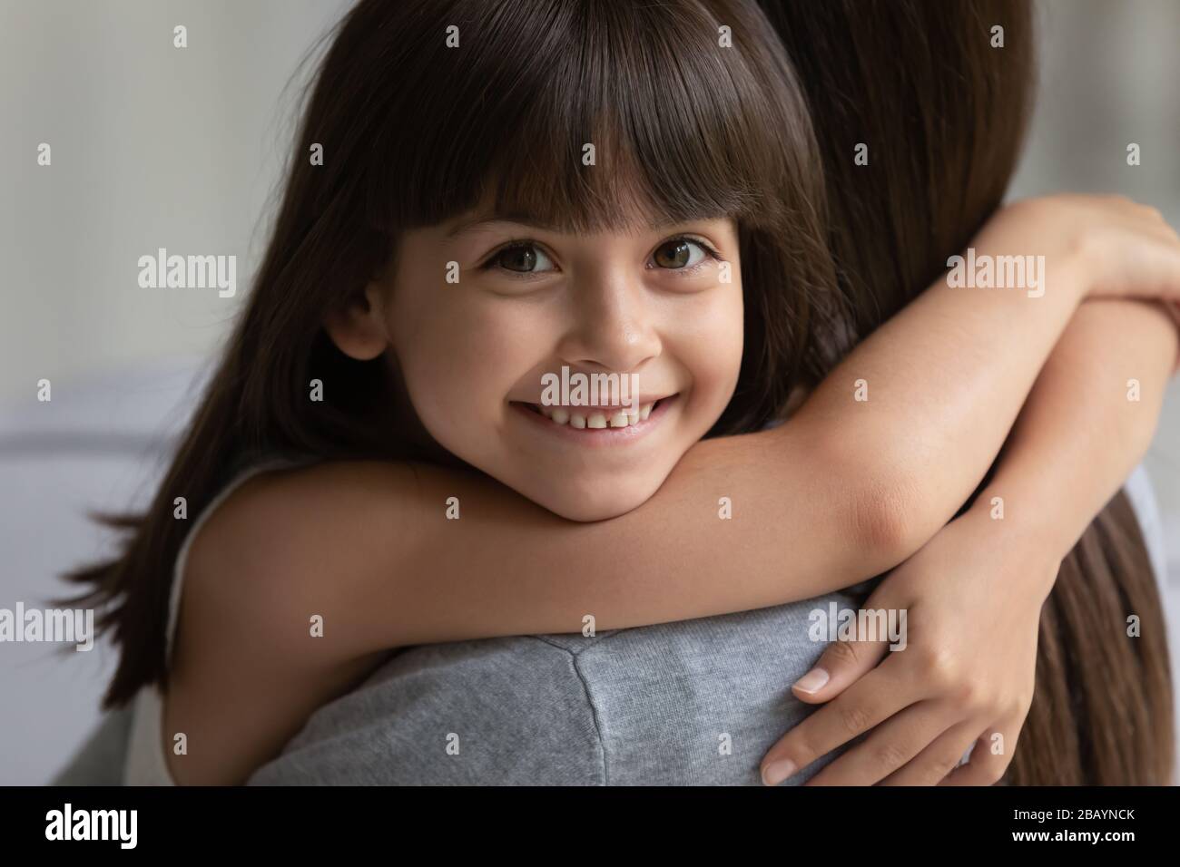 Portrait des lächelnden Mädchens umarmte Kuscheltiere mit der jungen Mutter Stockfoto