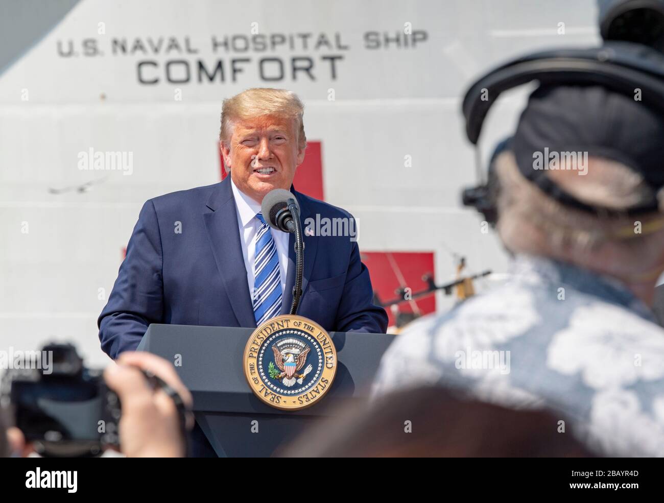 200328-N-UP035-1221 NORFOLK, Va. (28. März 2020) Präsident Donald J. Trump hält Bemerkungen auf der Naval Station Norfolk, 28. März, während seines Besuchs ab, um das Militär-Sealift-Kommando-Lazarettschiff USNS Comfort (T-AH-20) zu sehen. Trost bereitet sich auf den Einsatz zur Unterstützung der COVID-19-Reaktionsbemühungen des Landes vor und wird als Überweisungskrankenhaus für nicht-COVID-19-Patienten dienen, die derzeit in Krankenhäusern an Land eingeliefert werden. So können Krankenhäuser in Landhäusern ihre Bemühungen auf COVID-19-Fälle konzentrieren. Eine der Missionen des Verteidigungsministeriums ist die Verteidigungsunterstützung von Zivilbehörden. DoD unterstützt die Stockfoto