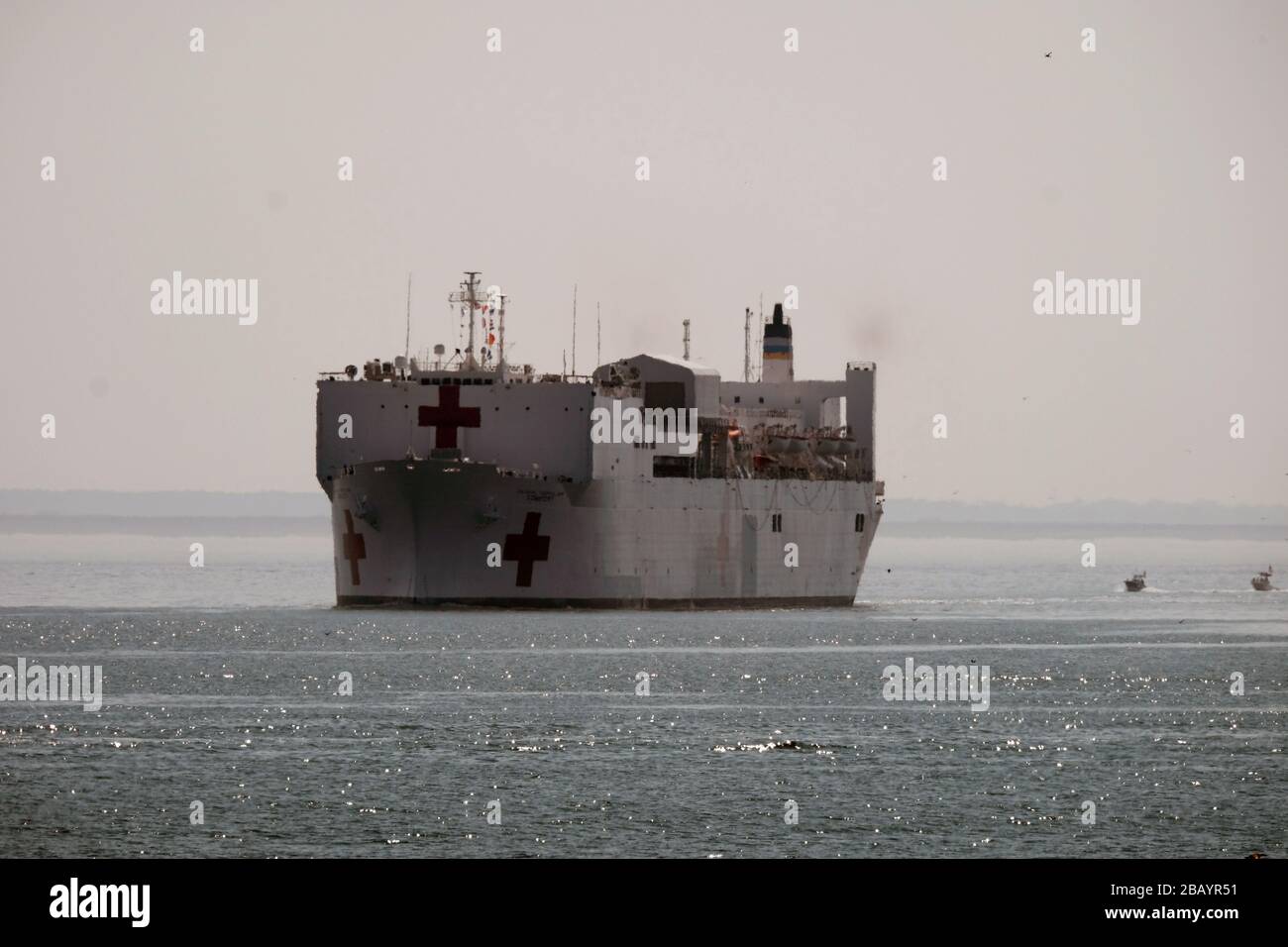 NORFOLK, Virginia (28. März 2020) - das Militär-Sealift-Kommando-Lazarettschiff USNS Comfort (T-AH 20) verlässt die Naval Station Norfolk, Virginia, 28. März 2020. Comfort unterstützt die COVID-19-Reaktionsbemühungen des Landes und dient als Überweisungskrankenhaus für nicht-COVID-19-Patienten, die derzeit in Landkrankenhäusern eingeliefert werden. So können Krankenhäuser in Landhäusern ihre Bemühungen auf COVID-19-Fälle konzentrieren. Eine der Missionen des Verteidigungsministeriums ist die Verteidigungsunterstützung von Zivilbehörden. DoD unterstützt die Bundeszentrale für Notfallmanagement, die federführende Bundesbehörde sowie die Landes- und Kommunalbehörden Stockfoto