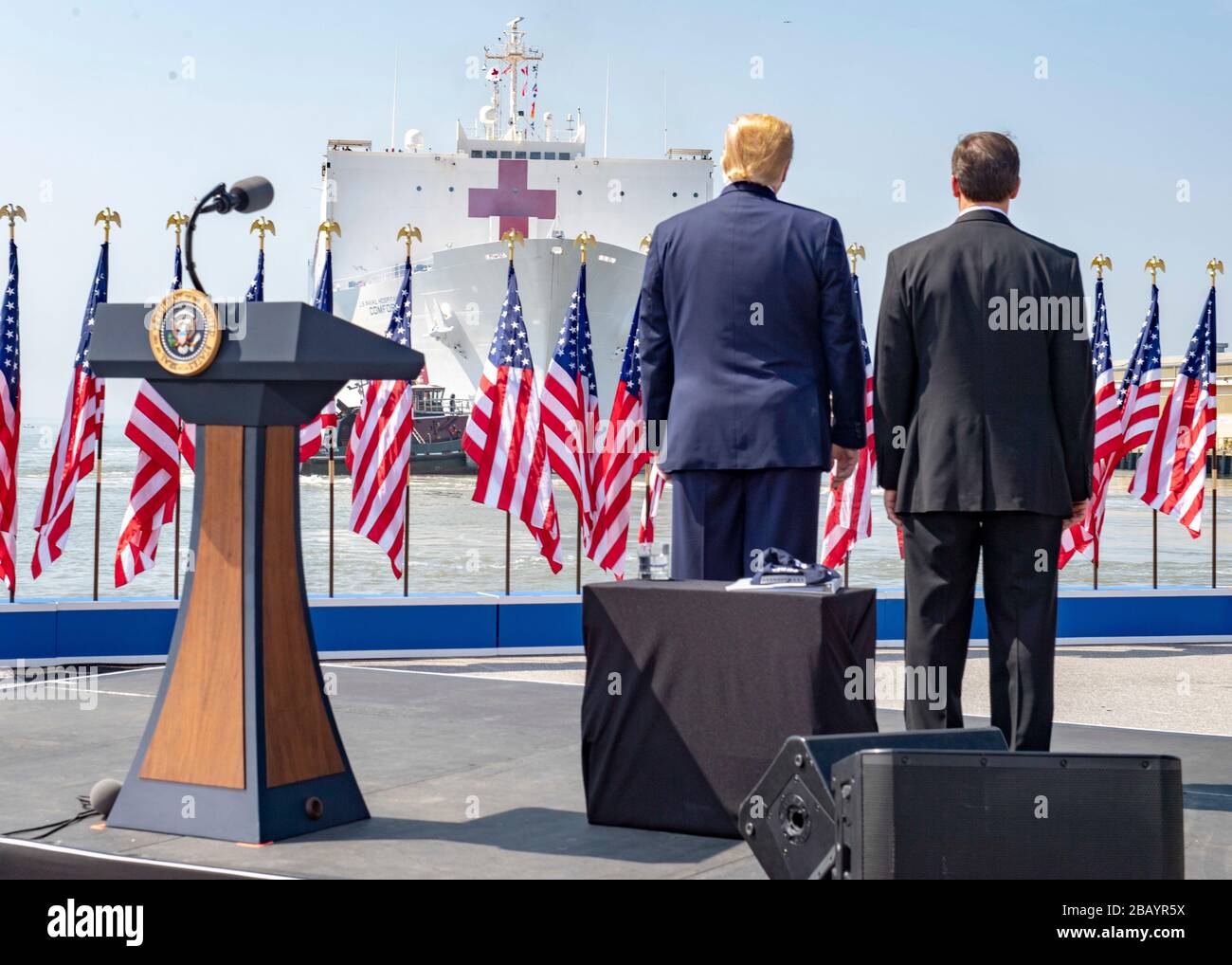 200328-N-UP035-1487 NORFOLK, Virginia (28. März 2020) Präsident Donald J. Trump und Verteidigungsminister Mark T. Esper beobachten, wie das Militär-Sealift-Kommando-Lazarettschiff USNS Comfort (T-AH-20) die Marinestation Norfolk, 28. März, verlässt. Trost bereitet sich auf den Einsatz zur Unterstützung der COVID-19-Reaktionsbemühungen des Landes vor und wird als Überweisungskrankenhaus für nicht-COVID-19-Patienten dienen, die derzeit in Krankenhäusern an Land eingeliefert werden. So können Krankenhäuser in Landhäusern ihre Bemühungen auf COVID-19-Fälle konzentrieren. Eine der Missionen des Verteidigungsministeriums ist die Verteidigungsunterstützung von Zivilbehörden. DoD ist supor Stockfoto