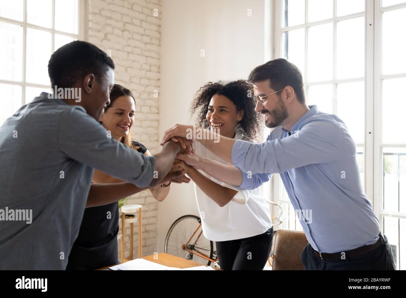 Freundliche Multiracial Teamkollegen, die Palmen zusammengestapelt haben, fühlen Einheit und Halt Stockfoto