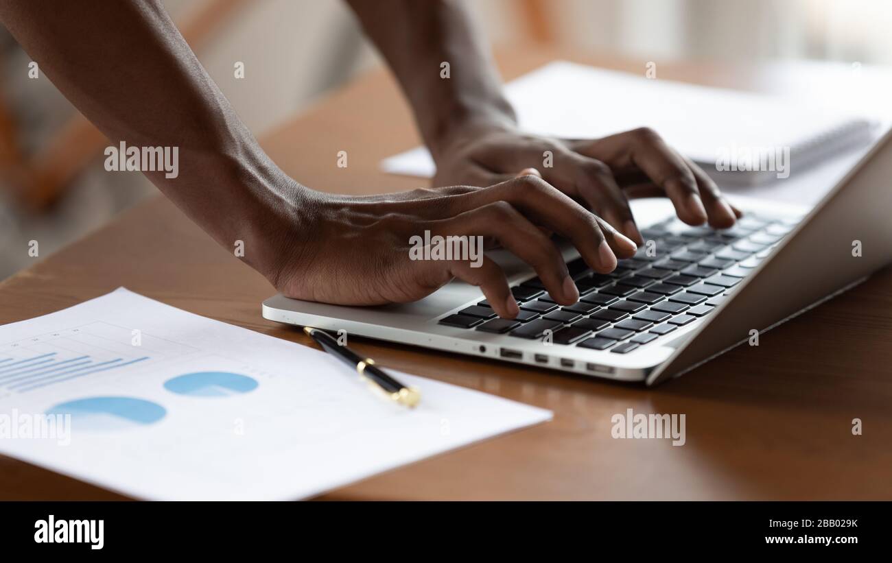Projektmanagerin des afrikanischen Geschäftsmannes tippt auf Laptop Nahansicht Stockfoto