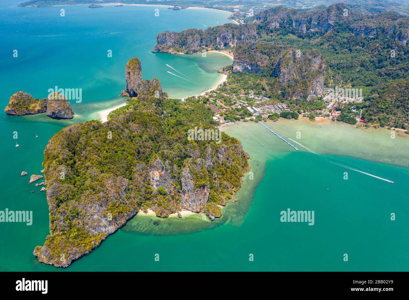 Luftdronblick auf einen schönen tropischen Strand, hoch aufragende Klippen und grünen Dschungel auf einer isolierten Halbinsel. (Railay Beach, Krabi) Stockfoto