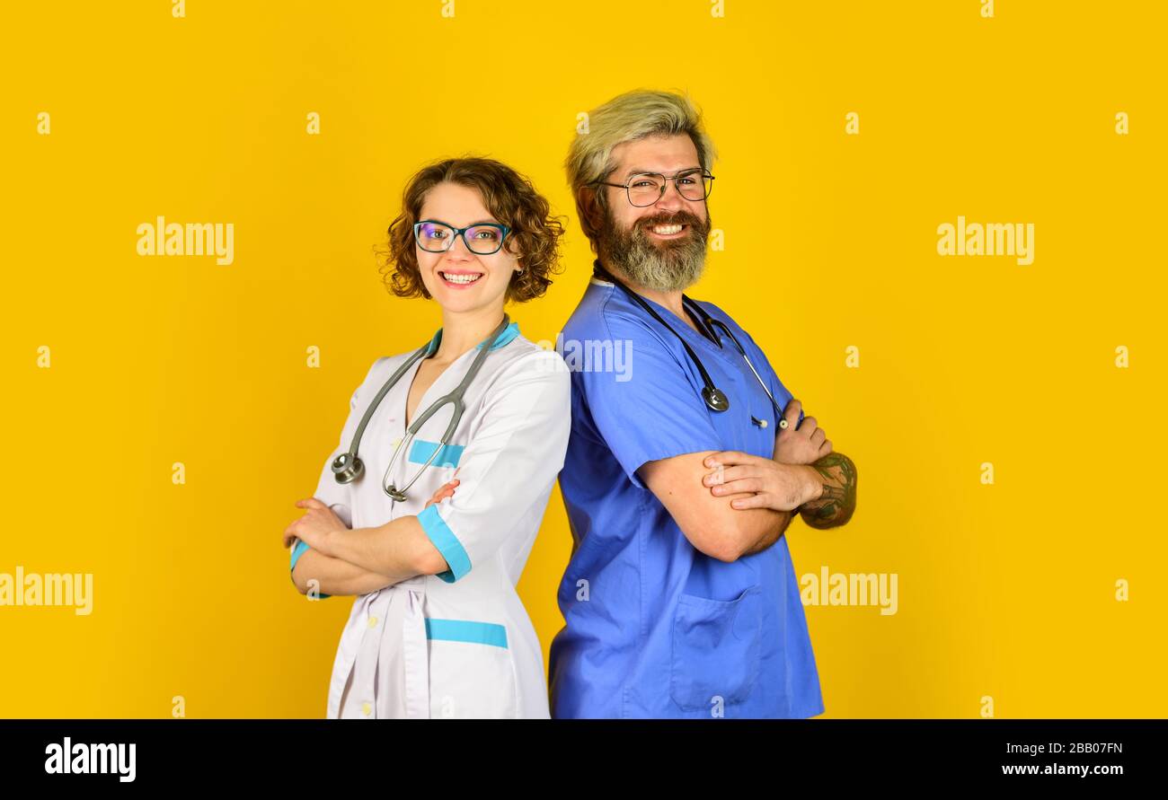 Erfolgreiches Team von Ärzten. Menschen in Uniformen gelber Hintergrund. Medizinisches Personal. Vertrauen Sie unseren Mitarbeitern. Gesundheitswesen, Teamarbeit und Personalkonzept. Arzt und Krankenschwester. Stockfoto