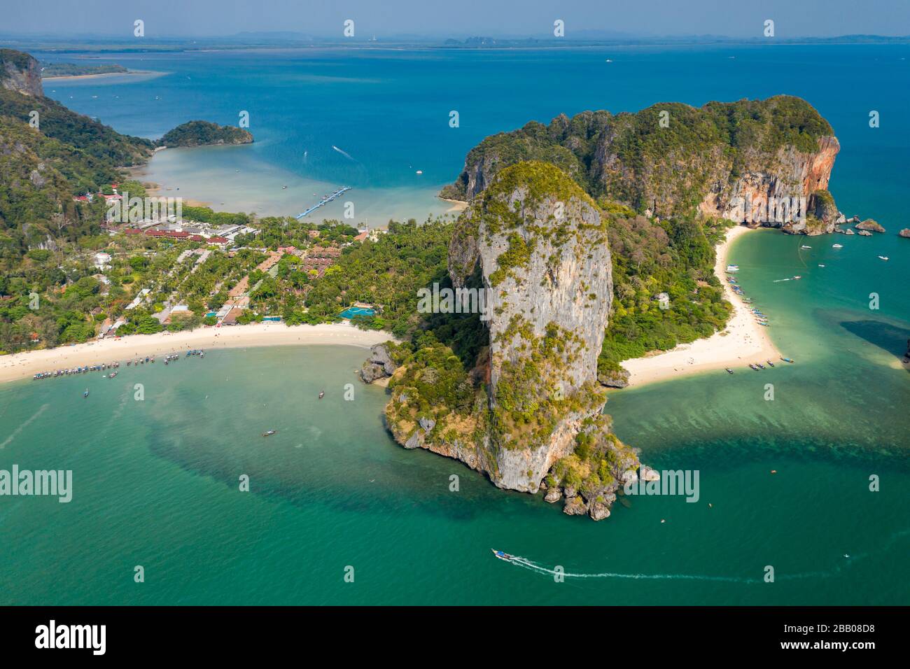 Luftdronblick auf einen schönen tropischen Strand, hoch aufragende Klippen und grünen Dschungel auf einer isolierten Halbinsel. (Railay Beach, Krabi) Stockfoto