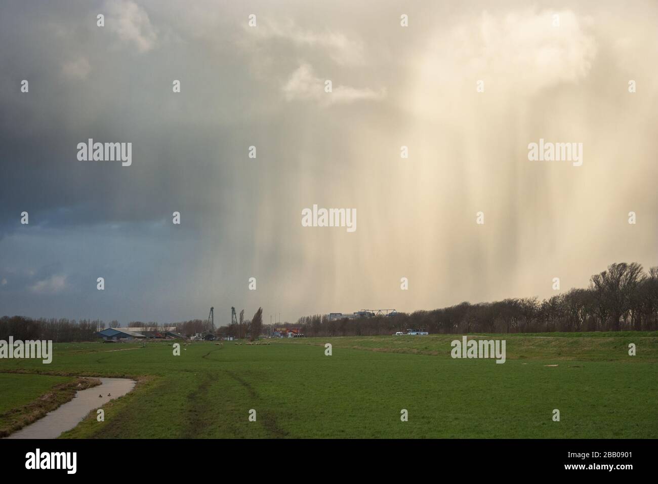 Dramatischer Himmel als winterliche Dusche bewegt sich über die holländische Polderlandschaft Stockfoto