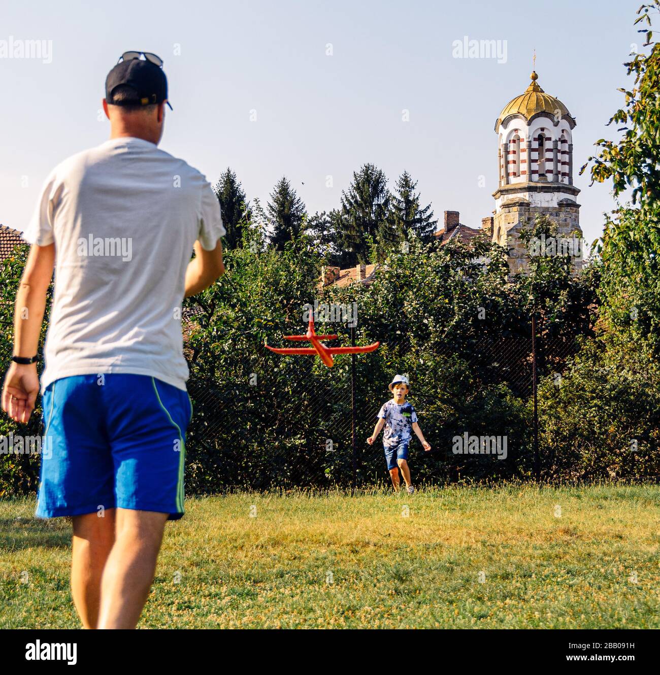 Kaukasischer Vater und Sohn glücklich und Spaß beim gemeinsamen Spielen und lernen, Modellflieger im Dorfpark zu fliegen.Bulgarien Stockfoto