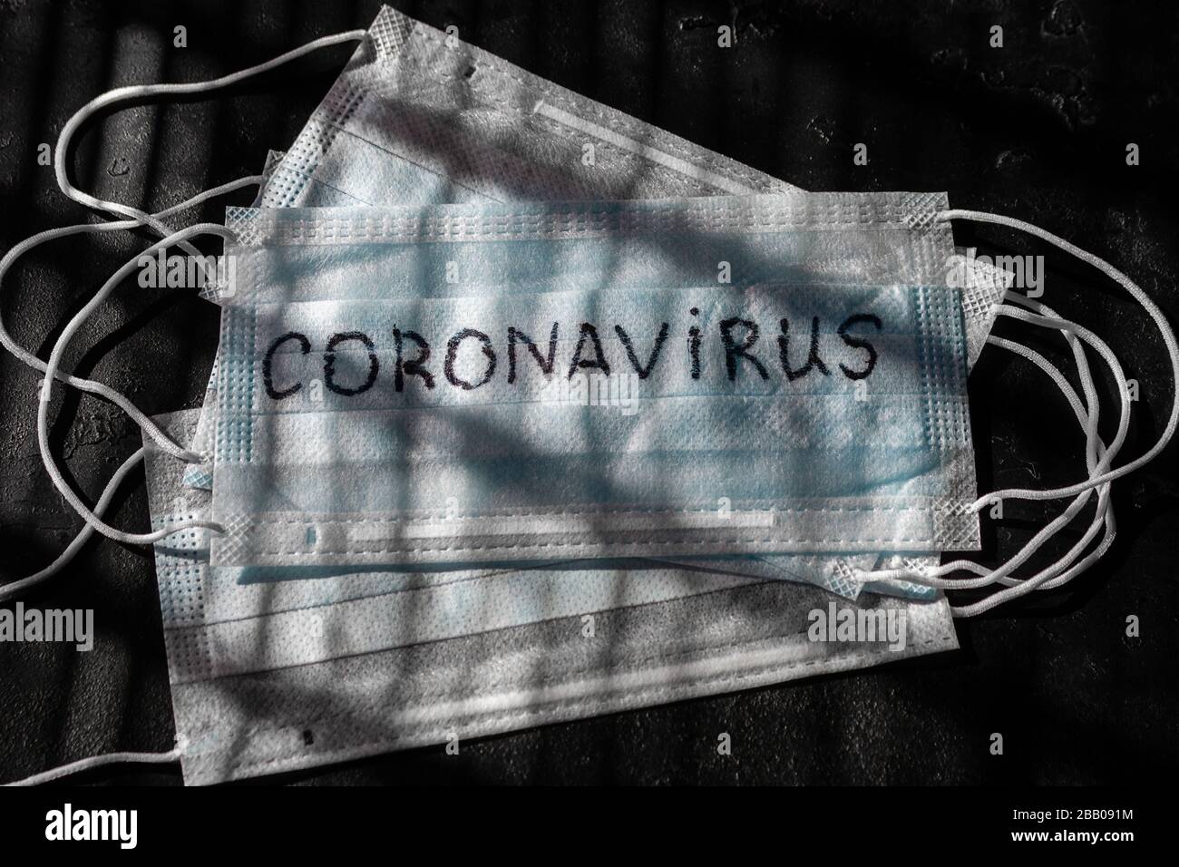 Medizinische Maske mit der Aufschrift Coronavirus auf schwarzem Grund Stockfoto