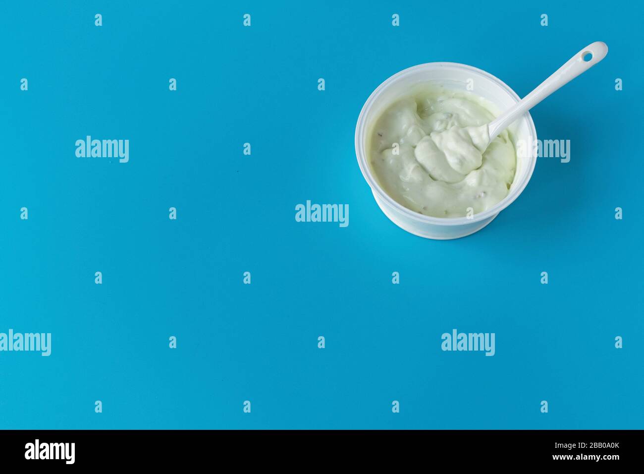 Joghurt in einem Glas auf blauem Hintergrund. Ein gesundes leichtes Diät-Frühstück. Milchprodukte. Stockfoto