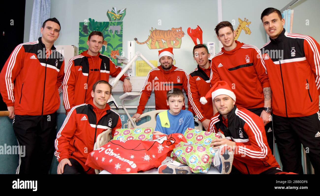 Nottingham Forest Spieler posieren mit einem Patienten in der Kinderstation. Stockfoto