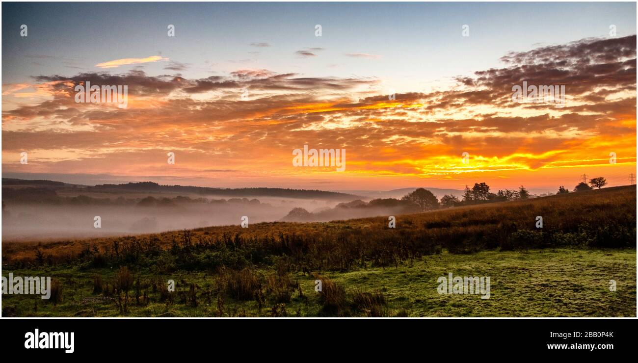 Sonnenaufgang über einem nebelgefüllten Tal Stockfoto